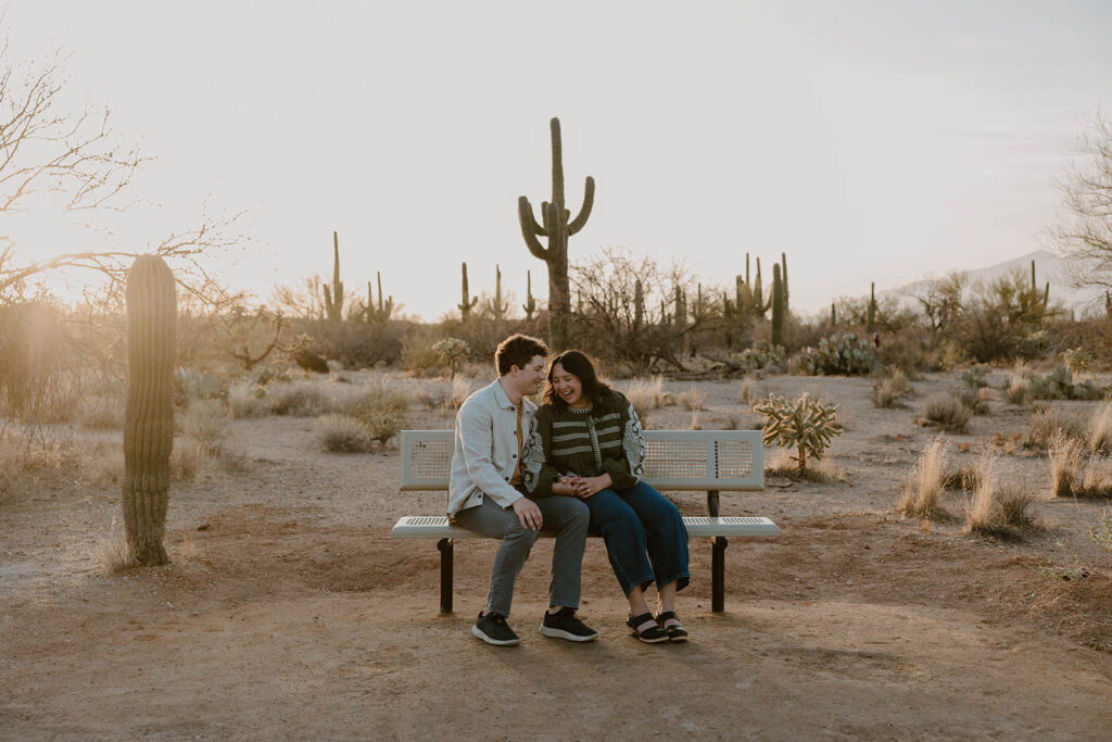 Engaged couple embracing in the desert at sunset 